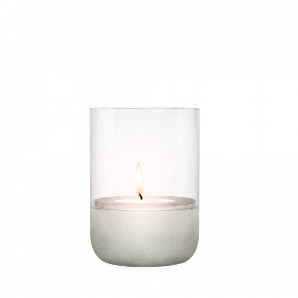 Moderne Kerze in einem Glas hält mit einem Betonfuß, sanft leuchtende Flamme.