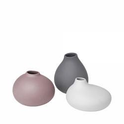 Three stylish ceramic vases in pink, gray, and white on a white background.