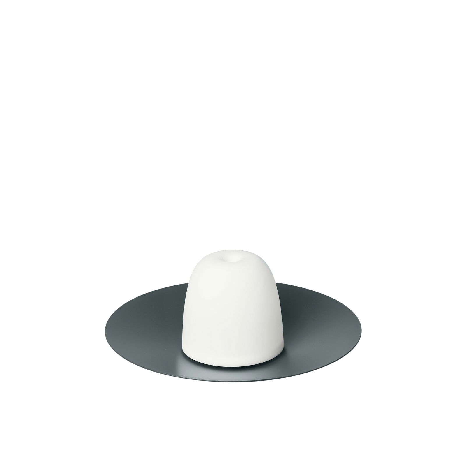 Minimalistisches weißes Keramikelement auf einem eleganten dunklen Teller, das moderne Designästhetik präsentiert.