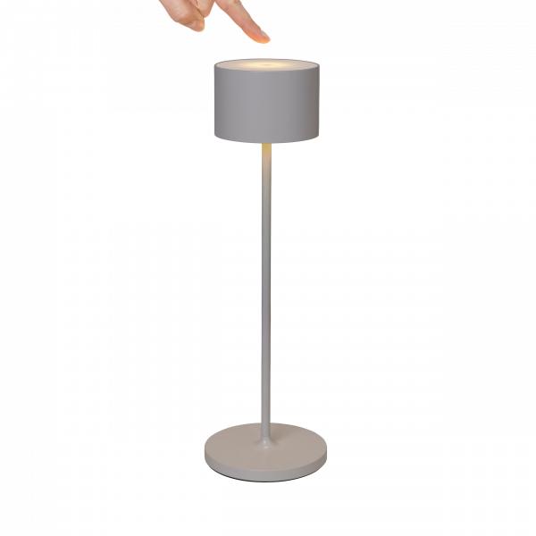 Modern grey floor lamp with a cylindrical shade and a hand pointing at it.