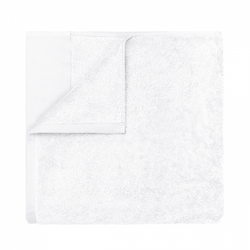 Soft white towel folded neatly on a black background.