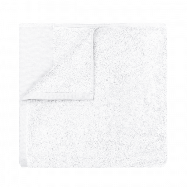 Soft white towel folded neatly on a black background.