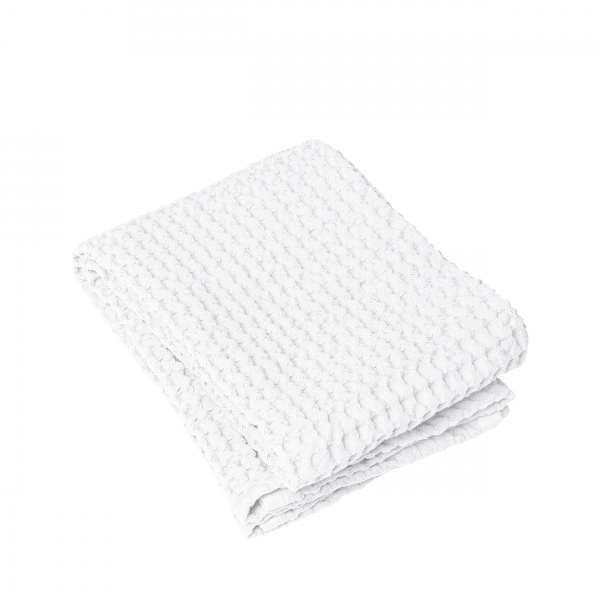 Folded white textured towel on a black background, perfect for home or spa use.