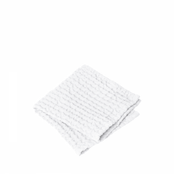 Gefaltetes weißes handgewebtes Handtuch auf schwarzem Hintergrund, ideal für Badezimmerdekoration.