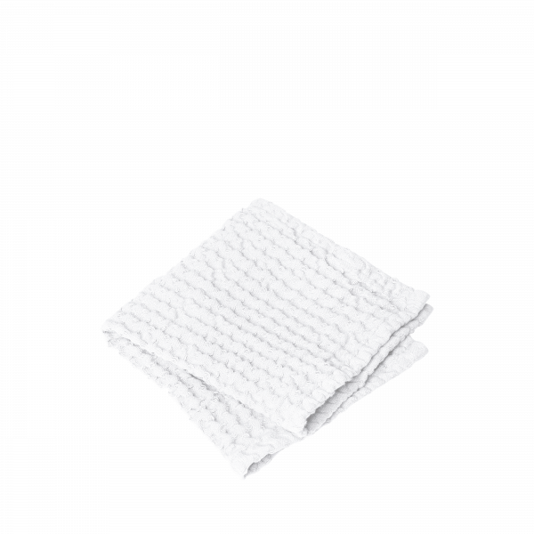 Gefaltetes weißes handgewebtes Handtuch auf schwarzem Hintergrund, ideal für Badezimmerdekoration.