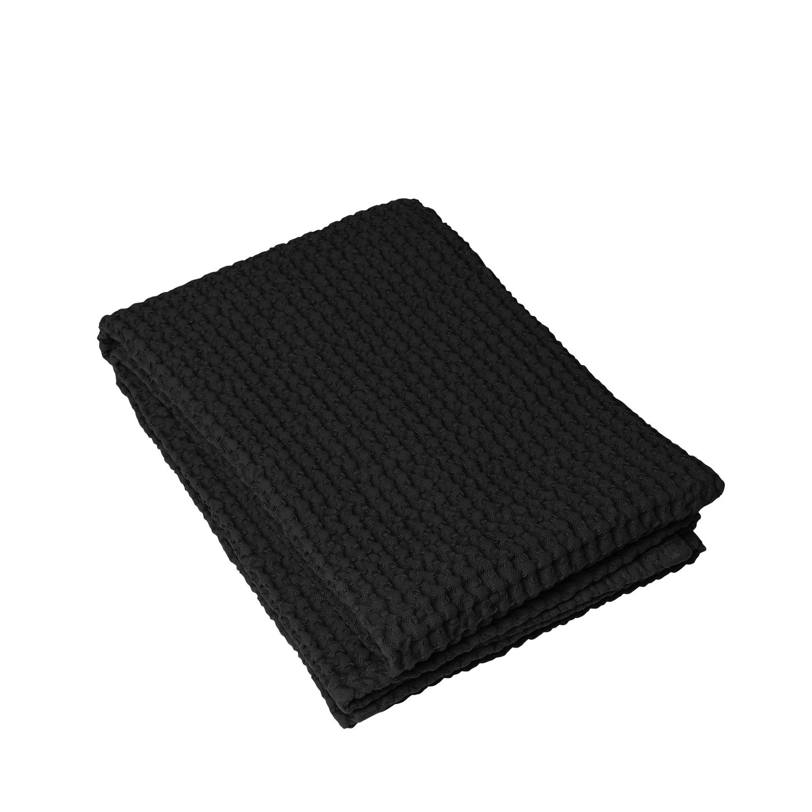 Gefaltete schwarze, strukturierte Decke auf schwarzem Hintergrund, ideal für gemütliche Wohnkultur.