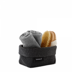 Cozy bathroom accessory set with towels and a brush in a stylish woven basket.
