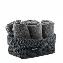 Gray towels neatly rolled in a stylish woven basket by Blomus.