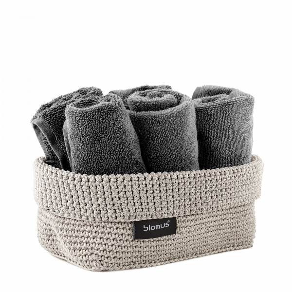 Gray rolled towels in a woven basket, perfect for stylish bathroom organization.