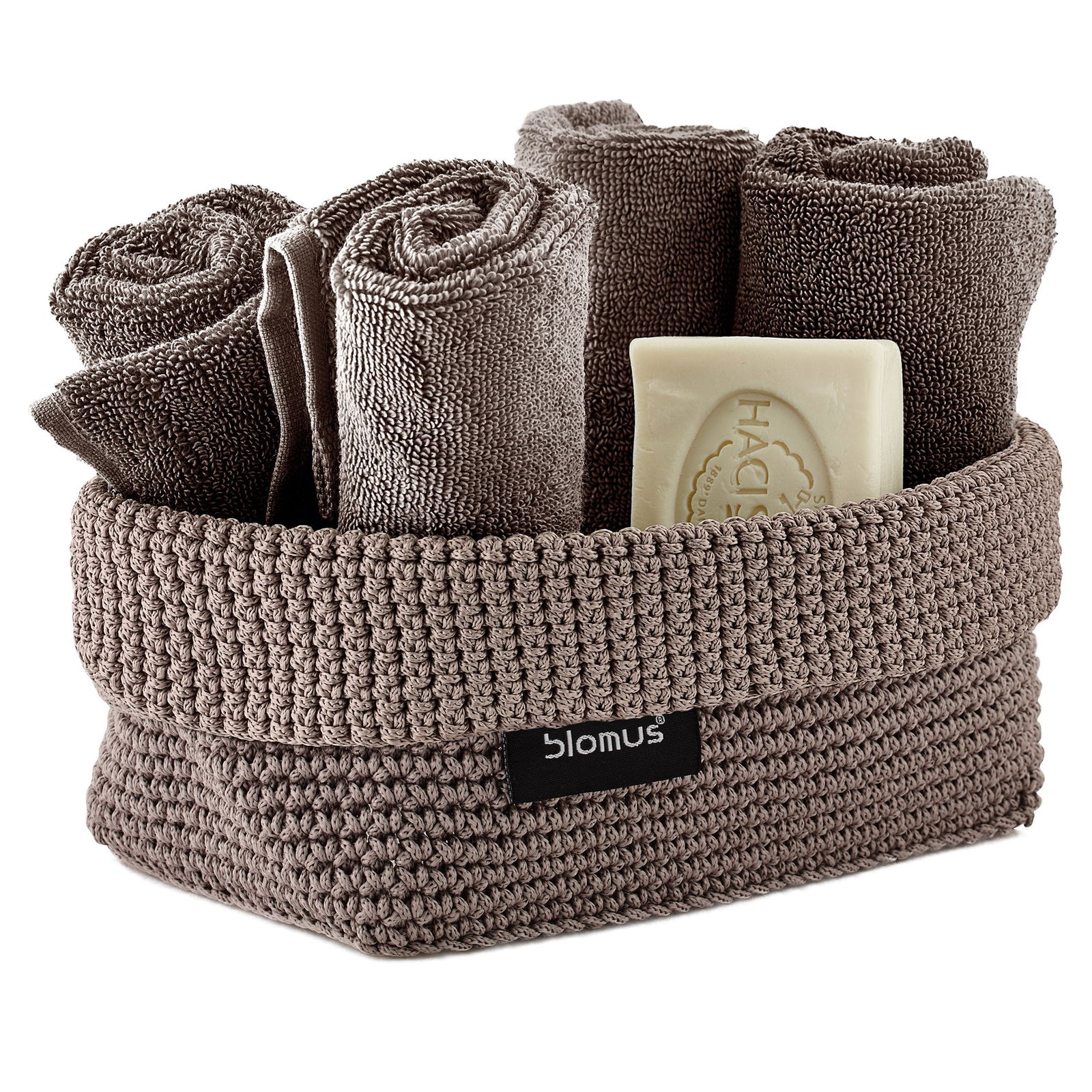 Weiche beige Handtücher und Seife in einem stilvollen geflochtenen Aufbewahrungskorb von Blomus.
