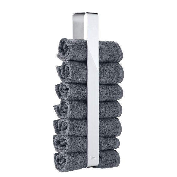 Moderne Handtuchhalter, der ordentlich gerollte graue Handtücher in einem stilvollen Badezimmer-Setting präsentiert.