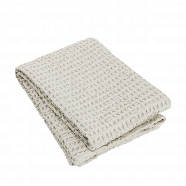 Soft cream-colored cotton blanket folded neatly, perfect for cozy home decor.