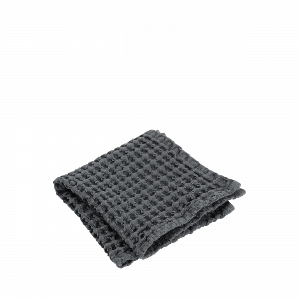 Weiche graue Waffle-Webdecke ordentlich auf einem weißen Hintergrund gefaltet.