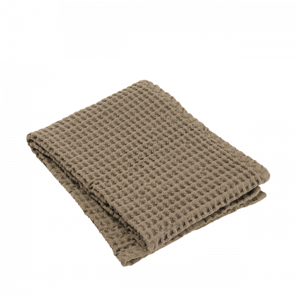 Cozy beige waffle weave blanket folded neatly on a white background.