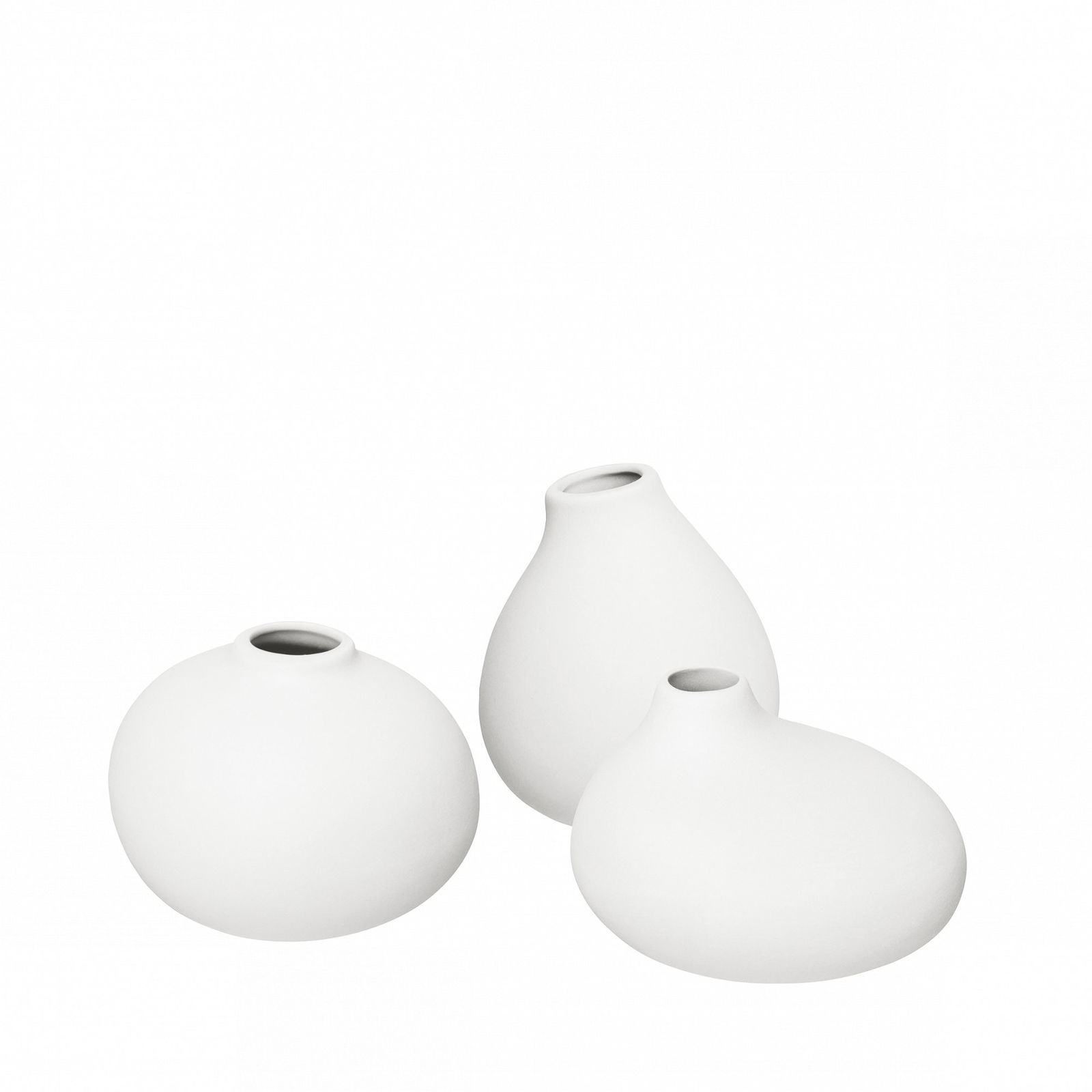 Three elegant white vases in modern shapes on a black background.