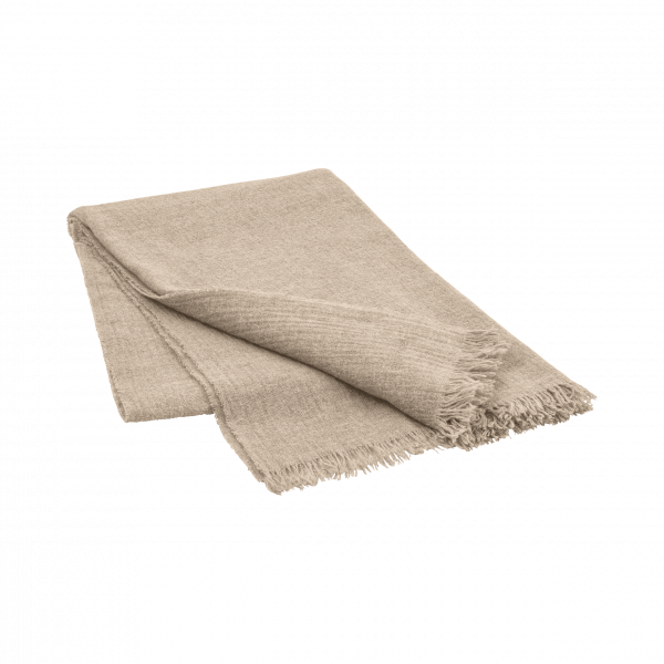 Soft beige blanket with frayed edges folded neatly on a black background.