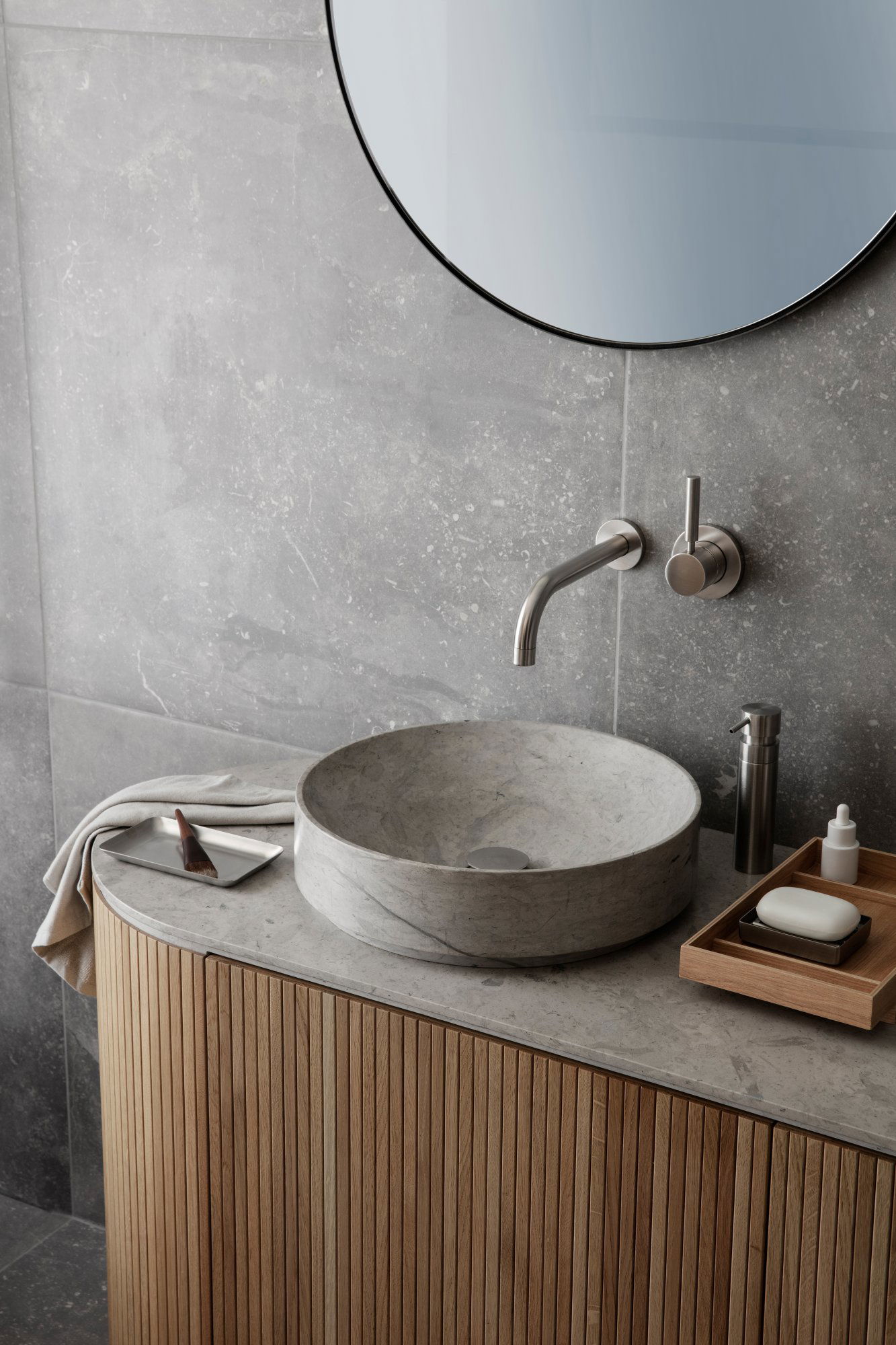Modern bathroom design featuring a marble sink and sleek fixtures on a wood vanity.