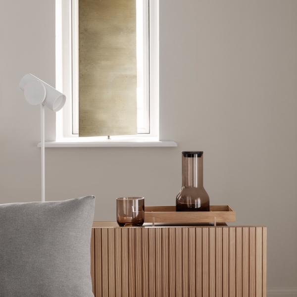 Modern living room decor featuring a stylish lamp, glassware, and wooden furniture.