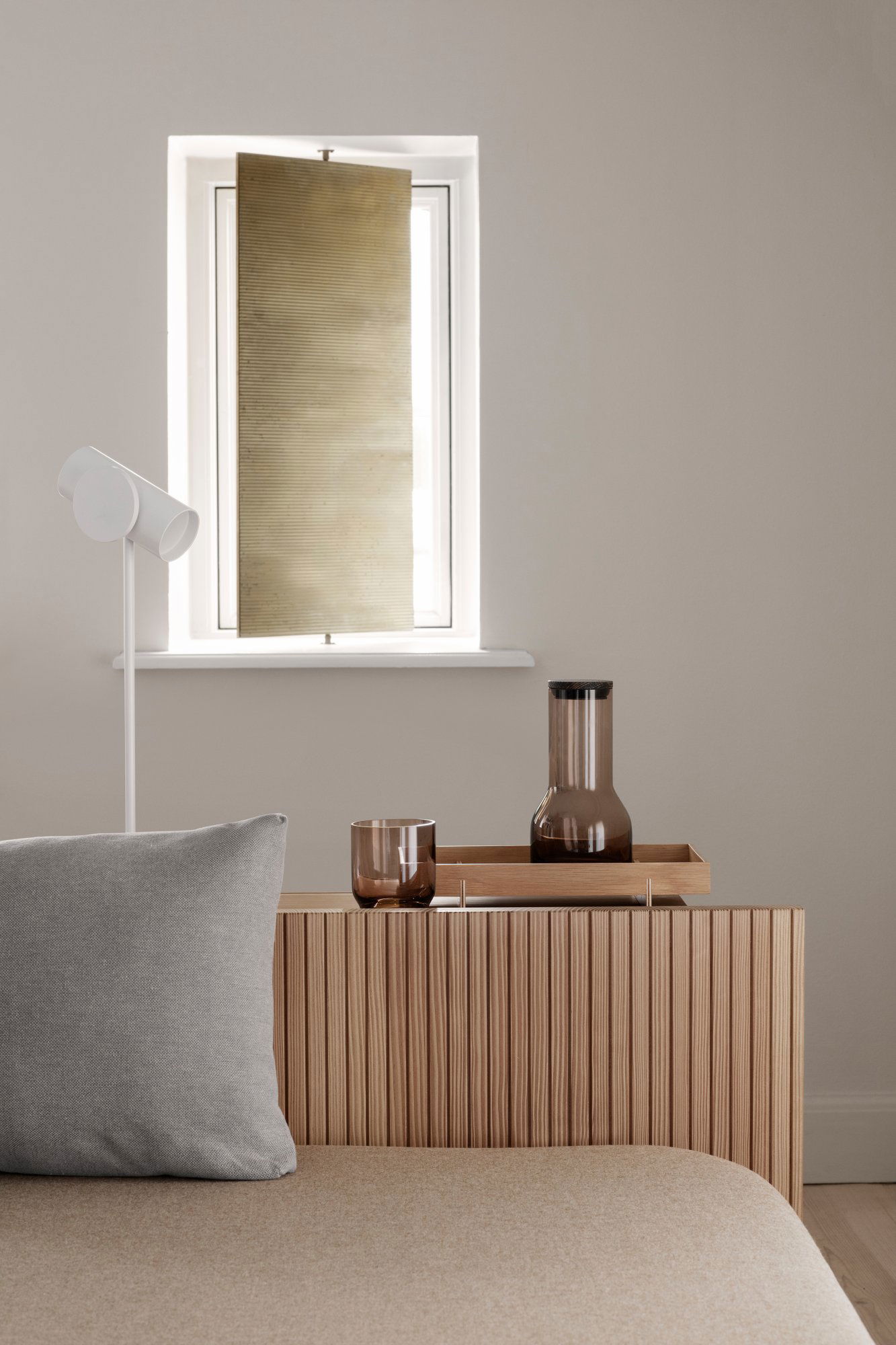 Modern living room decor featuring a stylish lamp, glassware, and wooden furniture.
