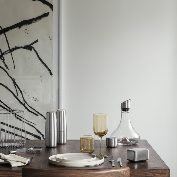Elegant dining set with modern glassware and decor on a wooden table.