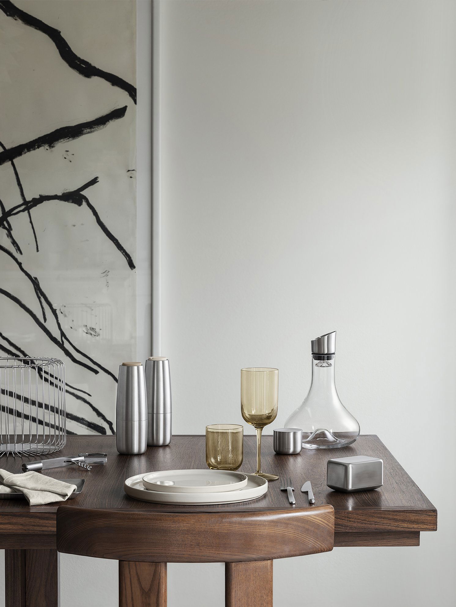 Elegant dining set with modern glassware and decor on a wooden table.