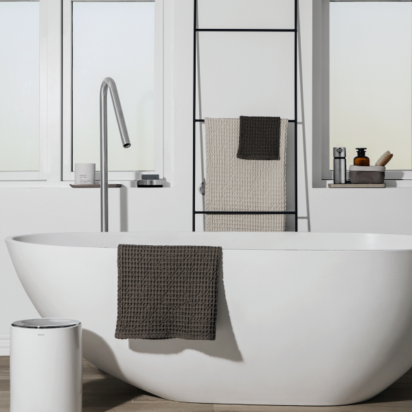 Modernes Badezimmer mit einer stilvollen freistehenden Badewanne und einer schicken Handtuchpräsentation.