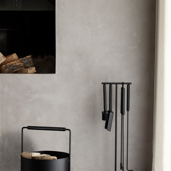 Moderner Kamin und eleganter Holzhalter vor einer minimalistischen Wand.