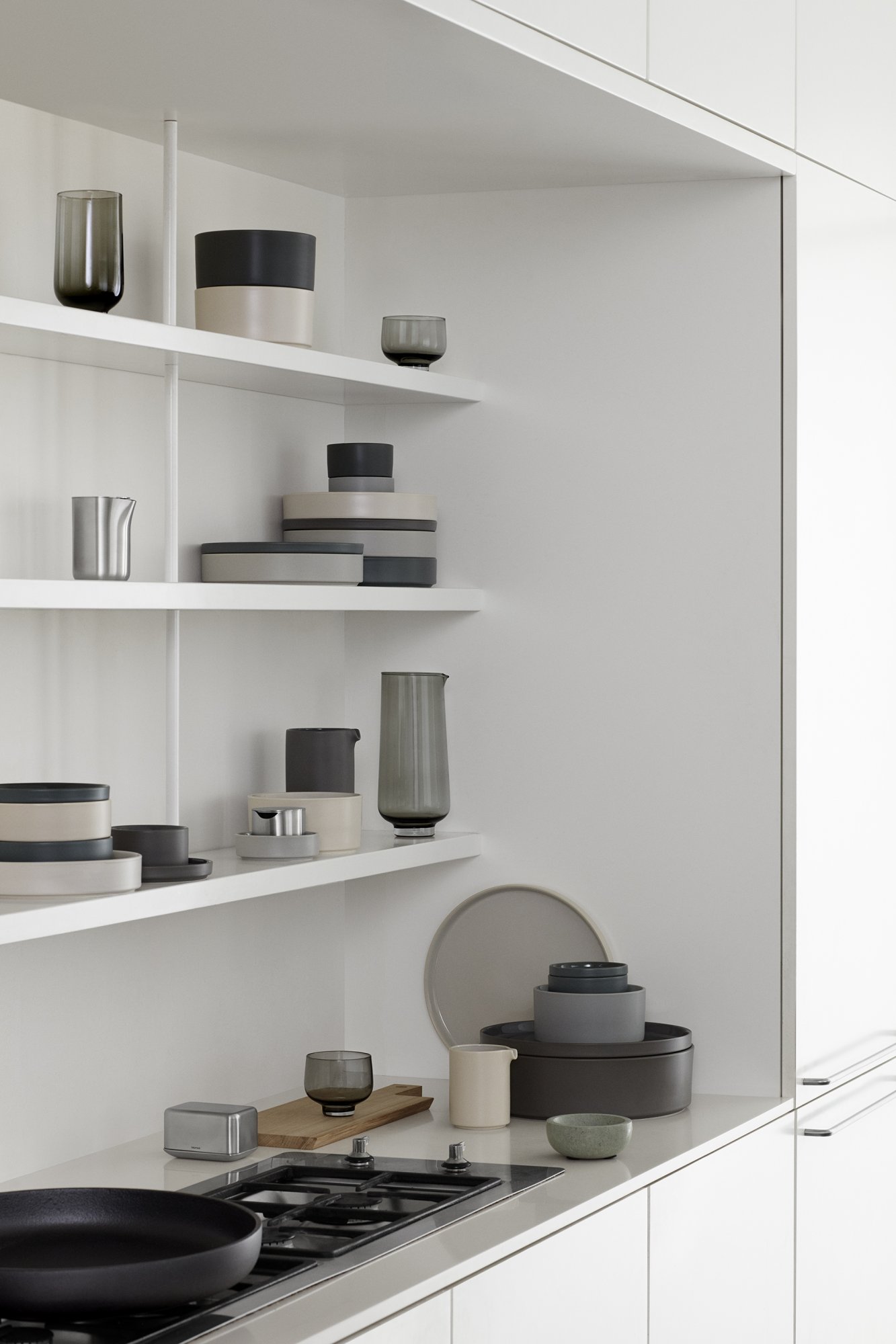 Minimalistische Kücheregale, die elegante Keramiken und Glaswaren in neutralen Farbtönen präsentieren.