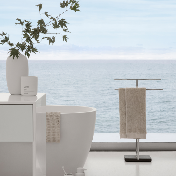 Modern bathroom with ocean view, featuring a sleek bathtub and elegant towel rack.