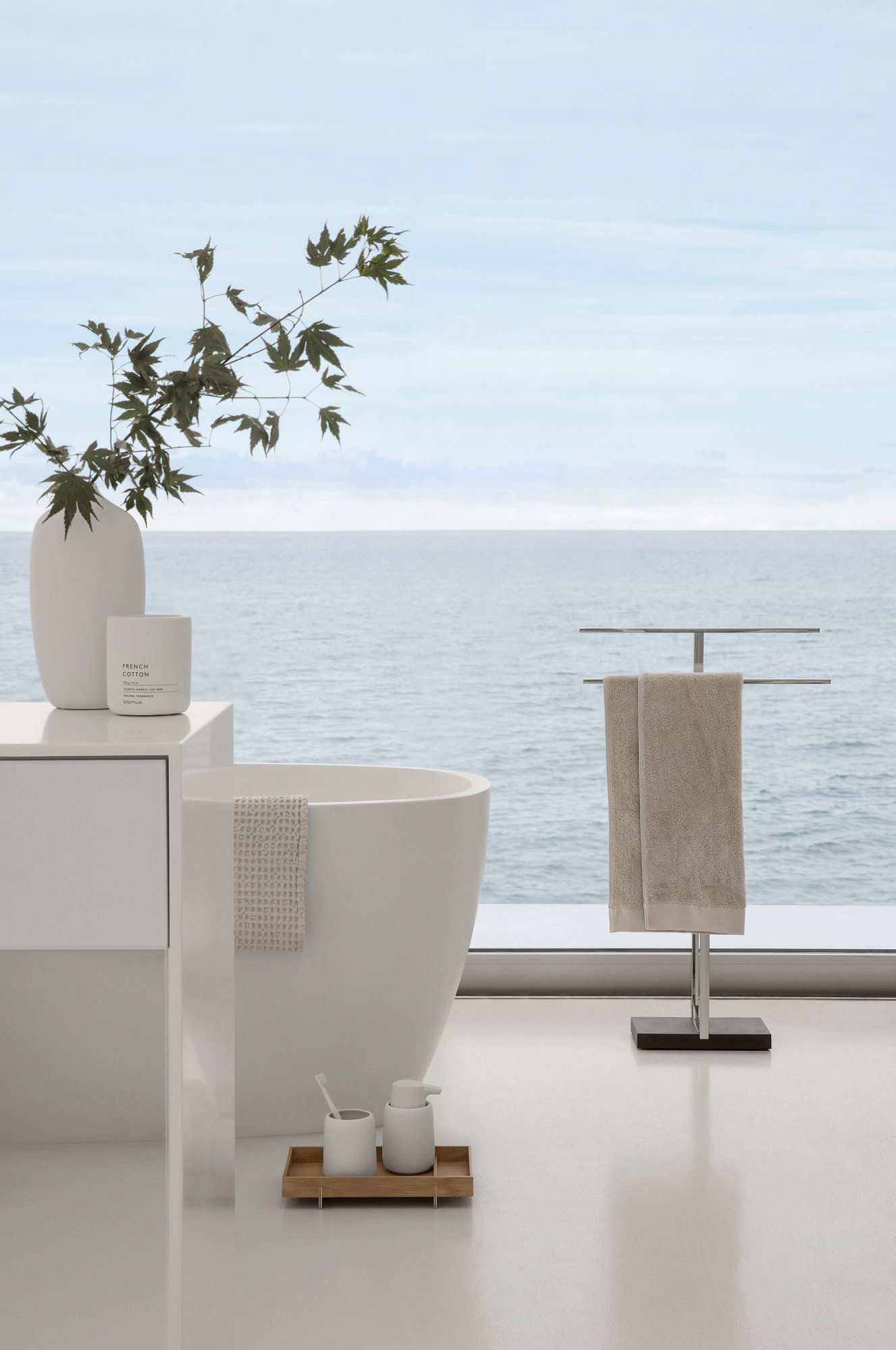 Modern bathroom with ocean view, featuring a sleek bathtub and elegant towel rack.