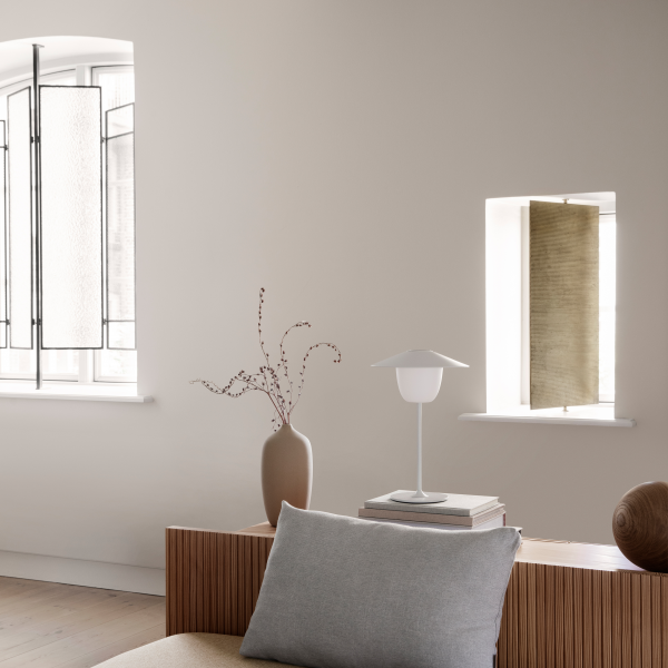 Modern interior design featuring a sleek vase, lamp, and elegant window decor.