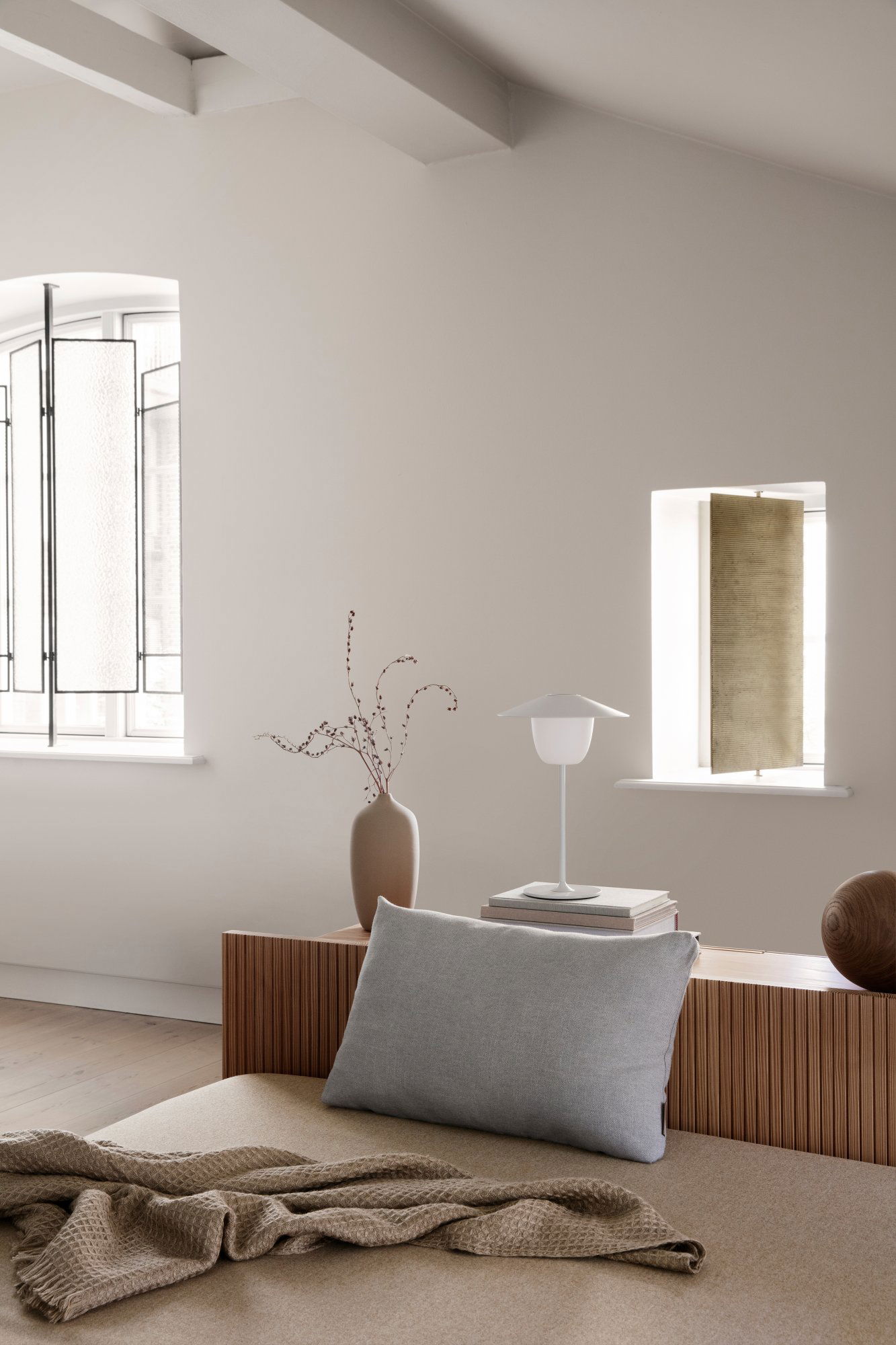 Modern interior design featuring a sleek vase, lamp, and elegant window decor.