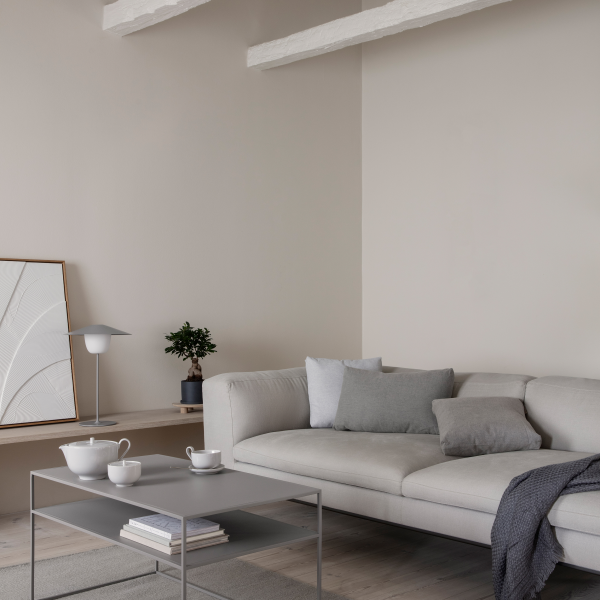Modern living room with a light gray couch, minimalist decor, and a stylish coffee table.