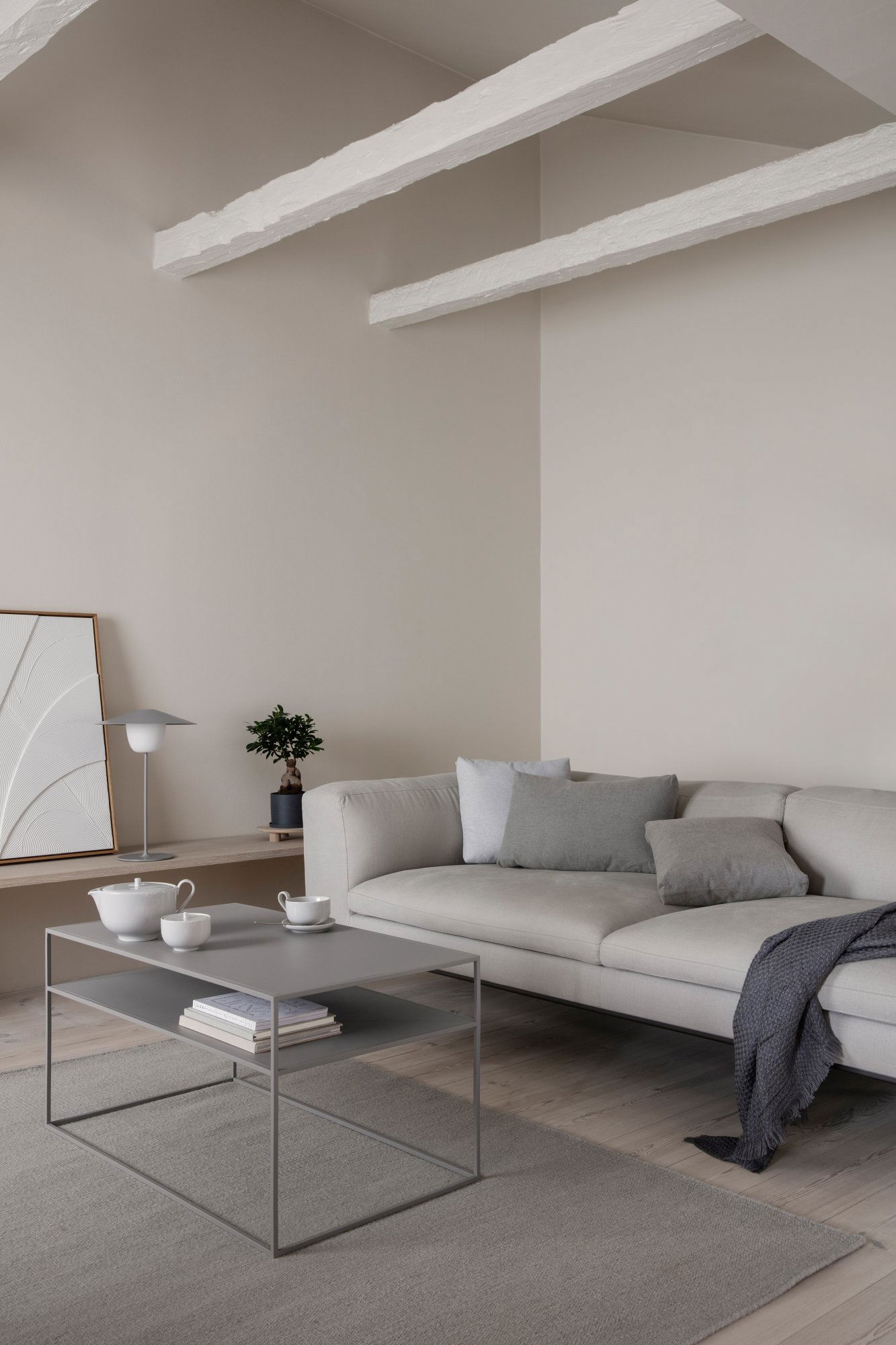 Modern living room with a light gray couch, minimalist decor, and a stylish coffee table.