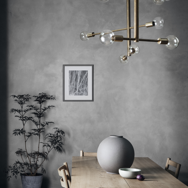 Modernes Esszimmer mit einem stilvollen Kronleuchter, minimalistischer Dekoration und Zimmerpflanzen.