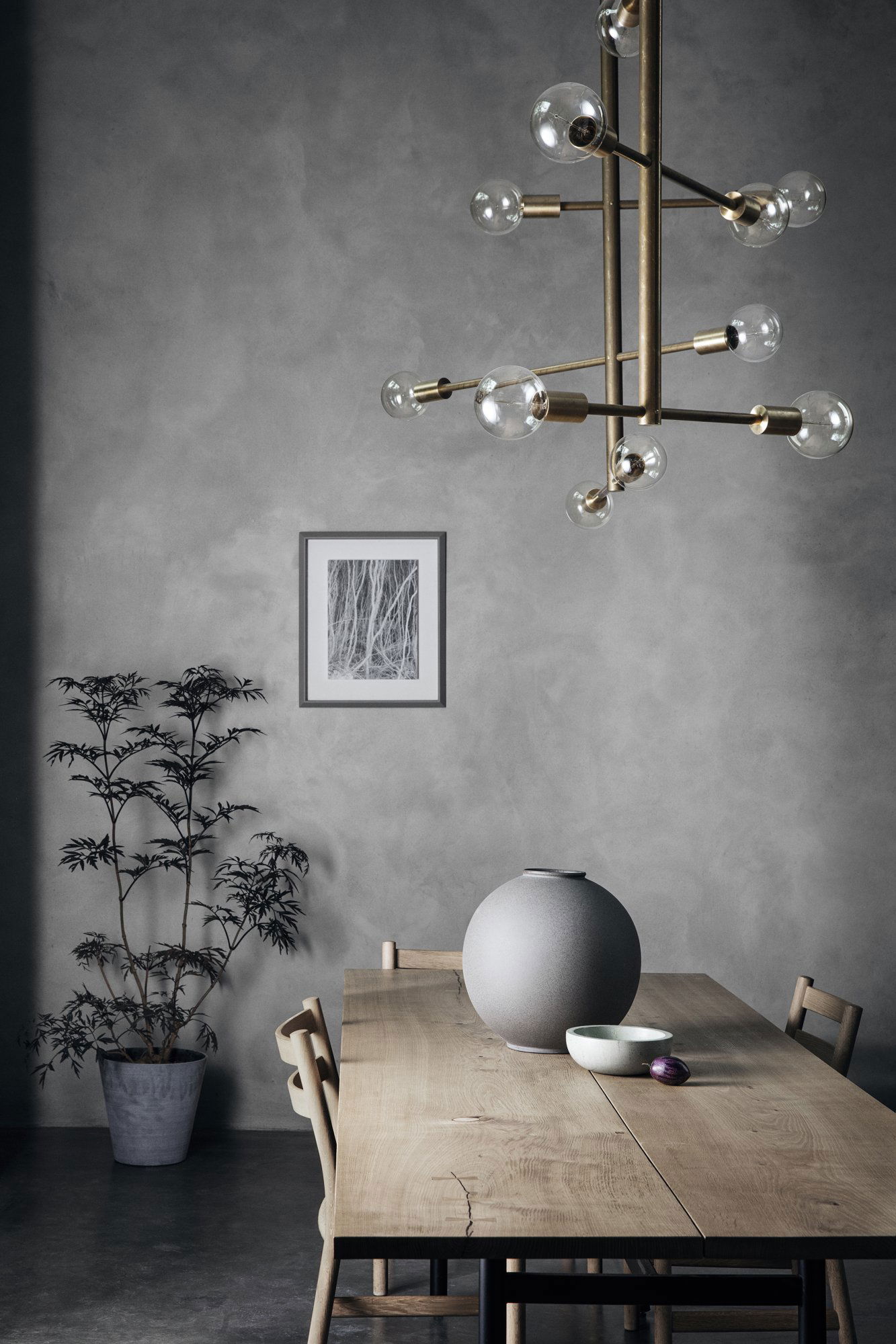 Modernes Esszimmer mit einem stilvollen Kronleuchter, minimalistischer Dekoration und Zimmerpflanzen.
