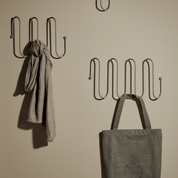Stylische Wandhaken, die einen Schal und eine Tragetasche vor einem neutralen Hintergrund zeigen.