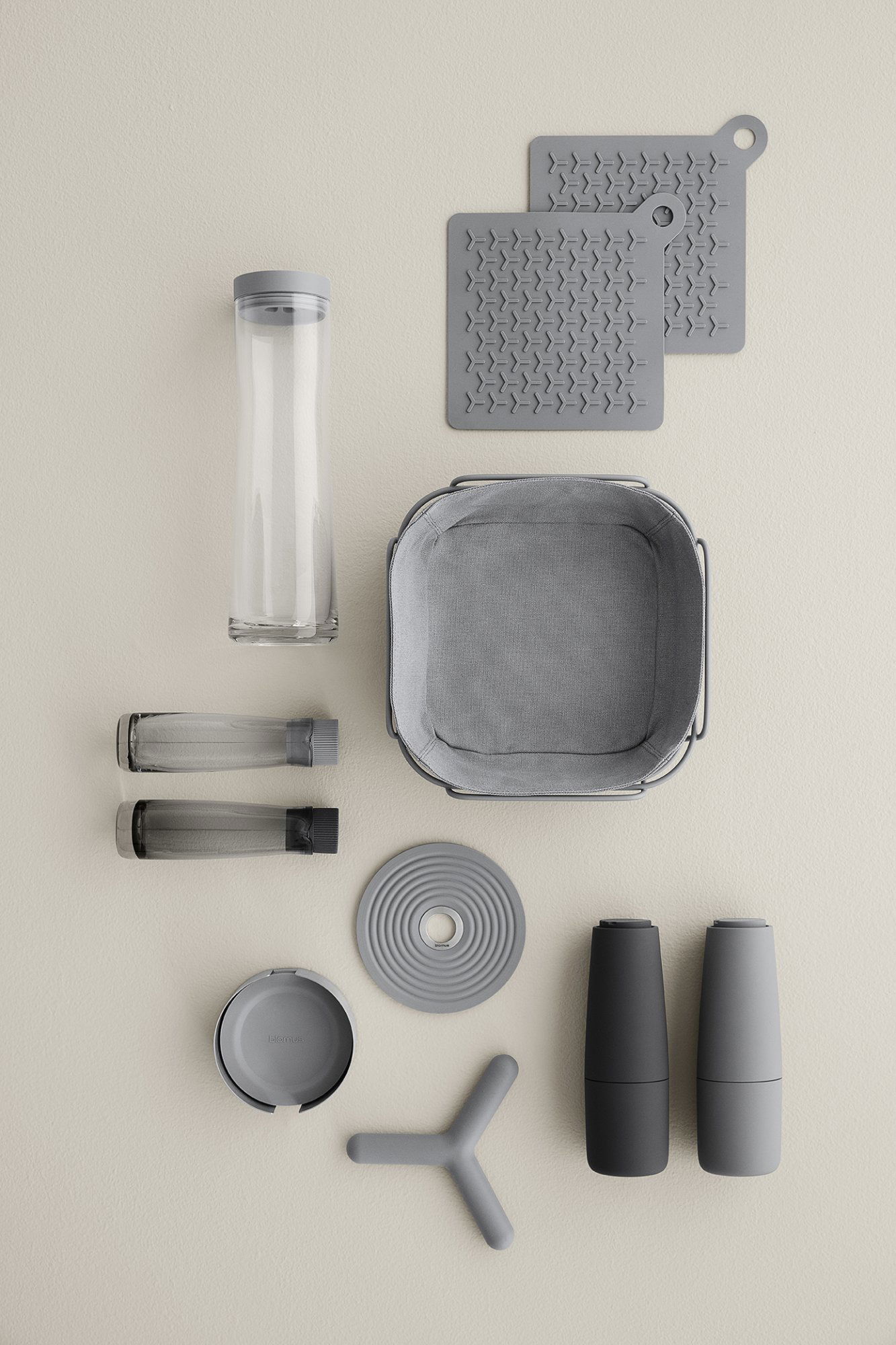 Modern kitchen organization tools including containers and mats on a neutral background.