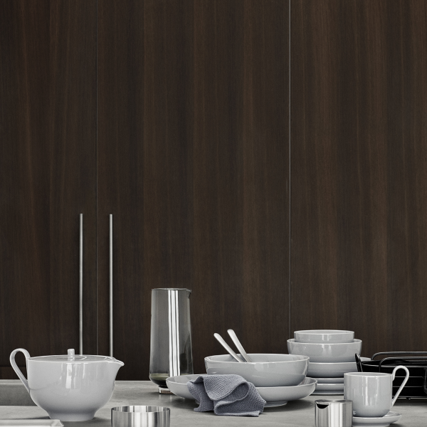 Modern kitchen scene featuring elegant tableware against a dark wood backdrop.
