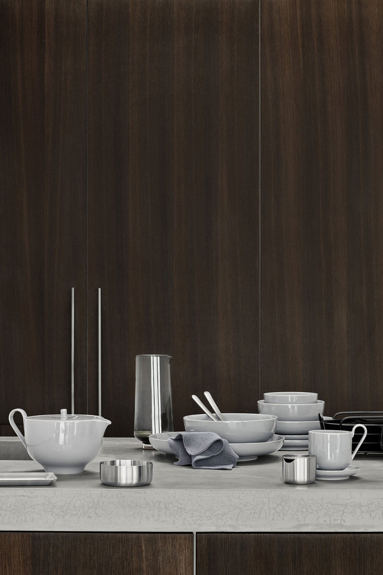 Modern kitchen scene featuring elegant tableware against a dark wood backdrop.