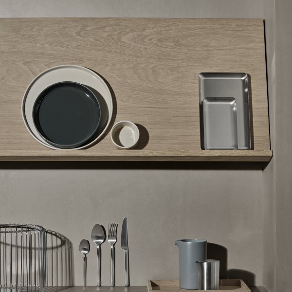 Moderne Küchenschrank mit verschiedenen Tellern, Besteck und minimalistischen Behältern.