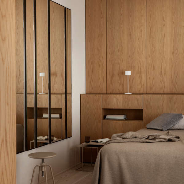 Gemütliches modernes Schlafzimmer mit Eichenholz-Akzenten, stylischem Spiegel und weichen Textilien.