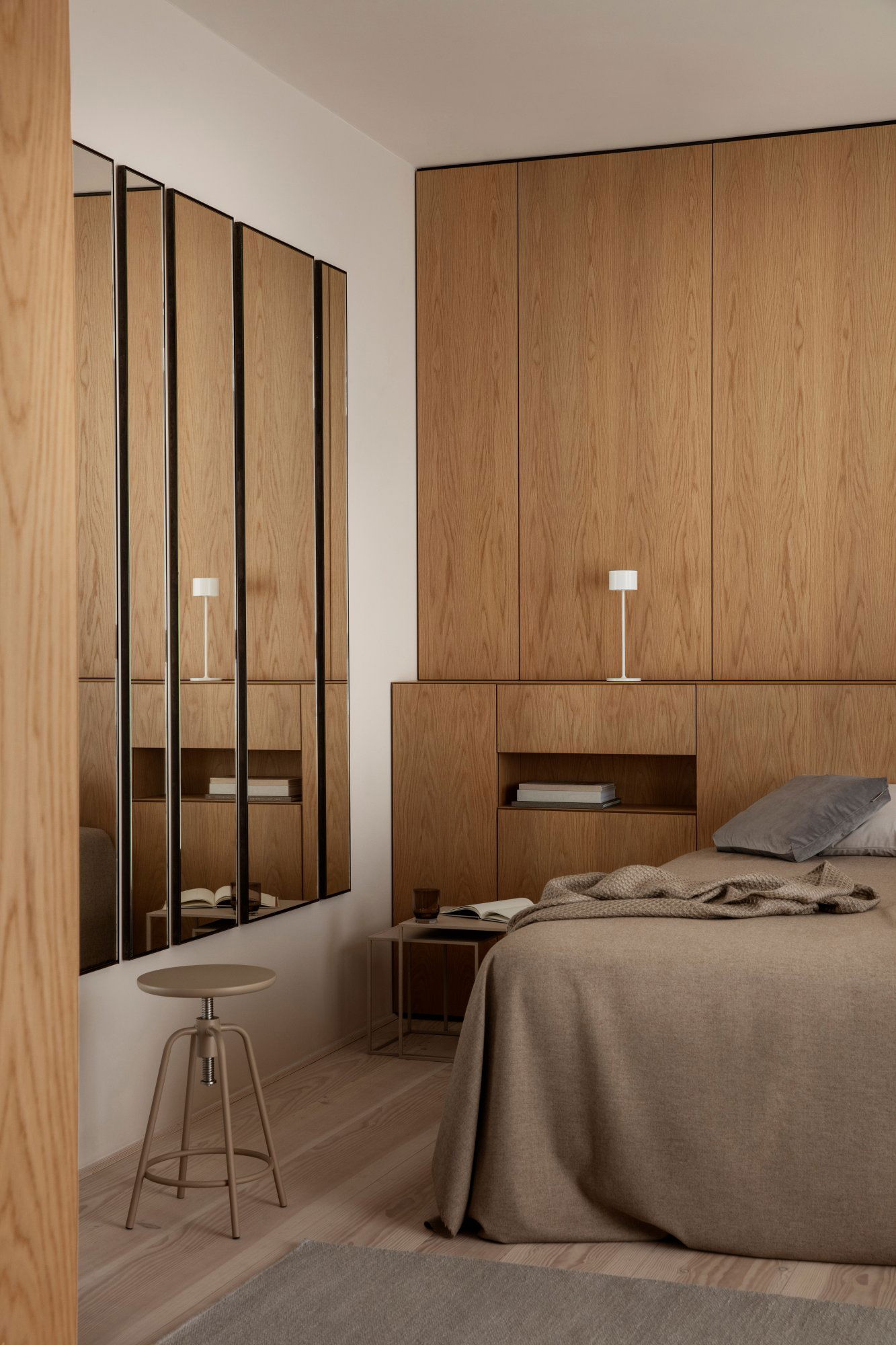 Gemütliches modernes Schlafzimmer mit Eichenholz-Akzenten, stylischem Spiegel und weichen Textilien.