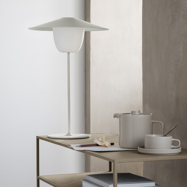 Modern minimalistic lamp with tableware on a stylish surface.