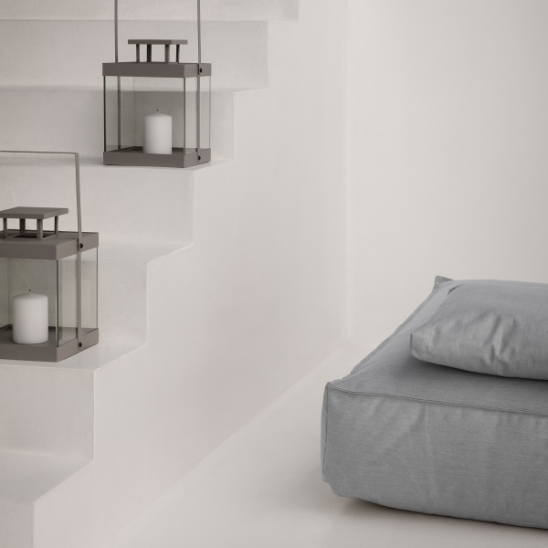 Cozy stairway with minimalist lanterns and a plush gray cushion for relaxation.