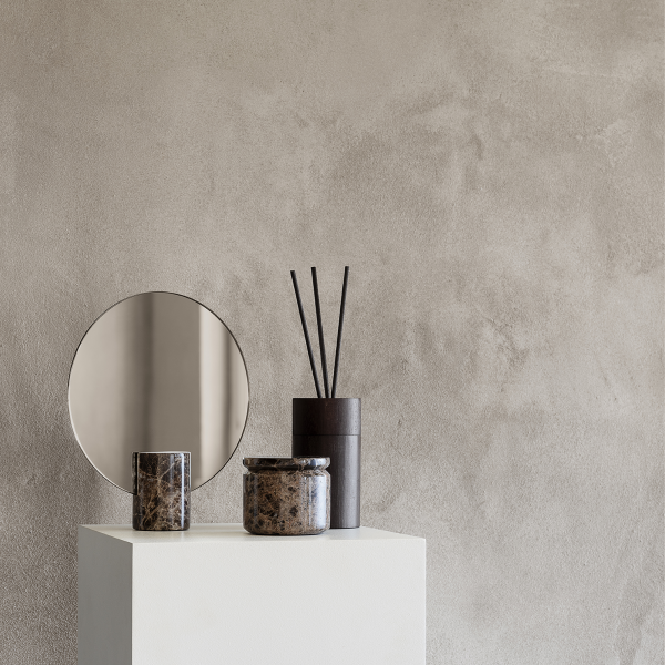 Moderne Dekoration mit dekorativen Vasen, einem Spiegel und Räucherstäbchen auf einem minimalistischen Podest.