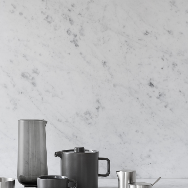 Stilvolles Teekannen- und Tassen-Set vor einem eleganten Marmor-Hintergrund für eine moderne Küchenaesthetik.