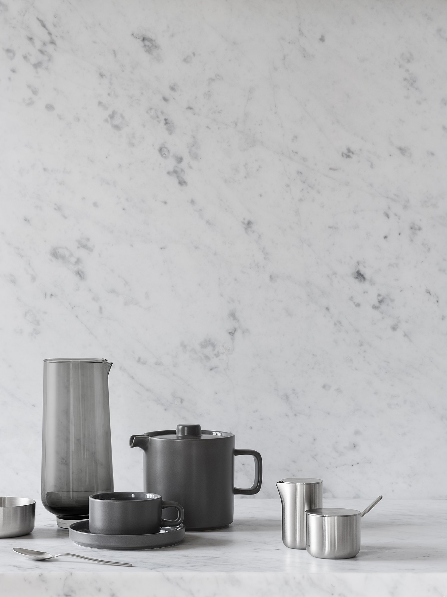 Stilvolles Teekannen- und Tassen-Set vor einem eleganten Marmor-Hintergrund für eine moderne Küchenaesthetik.