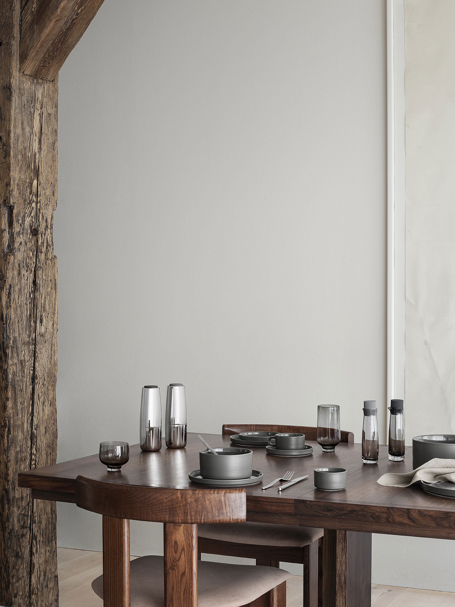 Elegant dining table setup with modern gray dishware and stylish glassware.