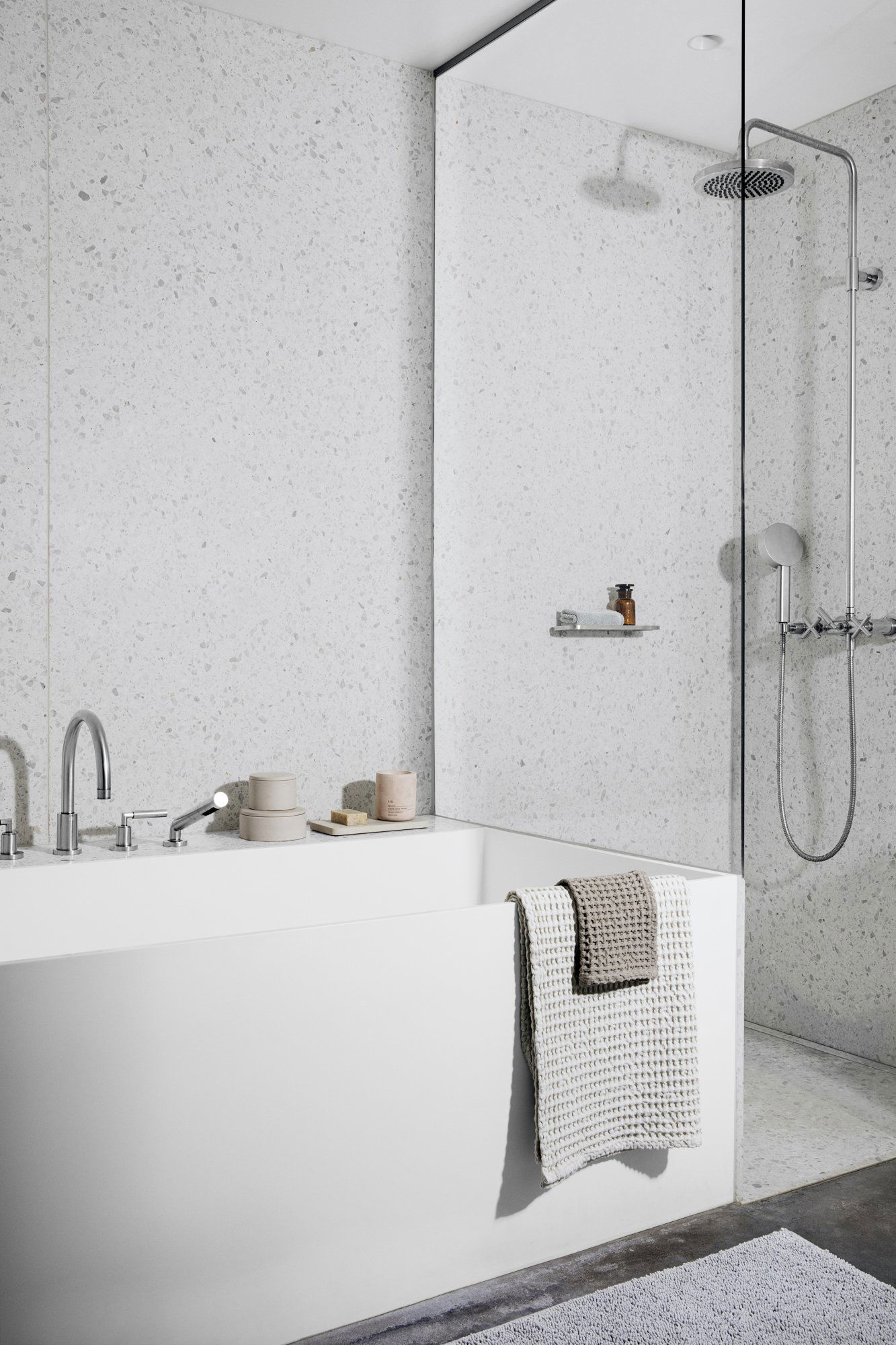 Modern bathroom design featuring a sleek tub and stylish shower area with minimalist decor.